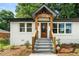 Close up of the entryway with beautiful gabled roof, wood columns, and modern exterior lighting at 2244 Alpha Dr, Decatur, GA 30032