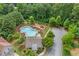 Aerial view of a community pool, playground, and surrounding lush greenery, perfect for Gathering enjoyment at 2307 Loughridge Dr, Buford, GA 30519