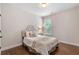 Cozy bedroom with a tufted headboard, hardwood floors, and natural light from a window at 2307 Loughridge Dr, Buford, GA 30519