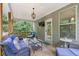 Inviting covered deck with comfortable seating, TV, and an entrance door to the home at 2307 Loughridge Dr, Buford, GA 30519