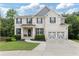 Charming two-story home with a brick facade, manicured lawn, and a two-car garage at 2307 Loughridge Dr, Buford, GA 30519