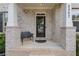 A welcoming front porch featuring brick columns and an attractive dark metal bench at 2307 Loughridge Dr, Buford, GA 30519