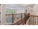 Second floor hallway overlooking the living room, featuring hardwood floors and wooden railing at 2307 Loughridge Dr, Buford, GA 30519