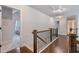 Hallway with hardwood flooring and decorative railing, leading to bedrooms and bathrooms at 2307 Loughridge Dr, Buford, GA 30519