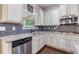 Well-lit kitchen with white cabinets, stainless steel appliances, and a stylish tile backsplash at 2307 Loughridge Dr, Buford, GA 30519