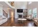 Open-concept living room with a stone fireplace, tall ceilings, and hardwood floors leading to the staircase at 2307 Loughridge Dr, Buford, GA 30519