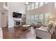 Bright living room with a stone fireplace, hardwood floors, large windows, and comfortable seating at 2307 Loughridge Dr, Buford, GA 30519
