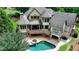 Aerial view of the back of the house, highlighting the deck, patio, pool, hot tub, and landscaped yard at 2910 Creek Tree Ln, Cumming, GA 30041