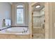 Beautiful bathroom featuring a soaking tub with tile surround, stained glass window, and tiled walk-in shower at 2910 Creek Tree Ln, Cumming, GA 30041