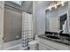 Cozy bathroom showcasing tub/shower combo, tiled walls, and vanity with a dark countertop at 2910 Creek Tree Ln, Cumming, GA 30041