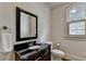 Powder room featuring a dark wood vanity with a marble countertop and decorative mirror at 2910 Creek Tree Ln, Cumming, GA 30041