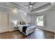 Charming bedroom featuring wood floors, tray ceiling, and a window with plantation shutters at 2910 Creek Tree Ln, Cumming, GA 30041
