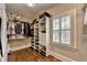 Organized walk-in closet with custom shelving and drawers, and a window with plantation shutters at 2910 Creek Tree Ln, Cumming, GA 30041