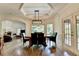 Elegant dining room with coffered ceilings, modern lighting, and scenic backyard view at 2910 Creek Tree Ln, Cumming, GA 30041