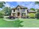 Stately residence showcasing lush greenery, stone details, and a curved walkway leading to the front entrance at 2910 Creek Tree Ln, Cumming, GA 30041