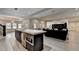 Open kitchen and living space with island, modern appliances, and hardwood floors at 2910 Creek Tree Ln, Cumming, GA 30041
