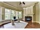Bright office space featuring a fireplace, hardwood floors, and many windows with plantation shutters at 2910 Creek Tree Ln, Cumming, GA 30041