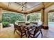 Covered outdoor dining area with a wood table, bench seating, and views of the lush yard at 2910 Creek Tree Ln, Cumming, GA 30041
