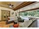 Inviting covered patio with ceiling fan, wicker furniture, and views of the pool and lush landscaping at 2910 Creek Tree Ln, Cumming, GA 30041
