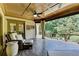 Relaxing porch with ceiling fan and outdoor seating area, offering a tranquil view of lush greenery at 2910 Creek Tree Ln, Cumming, GA 30041