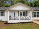 Inviting covered front porch with decorative railing accents the freshly painted white brick exterior at 8535 Hiram Acworth Hwy, Dallas, GA 30157
