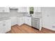Updated kitchen features white cabinets, stainless steel dishwasher, granite countertops, and wood flooring at 8535 Hiram Acworth Hwy, Dallas, GA 30157