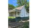 Exterior view of a one-story house with white siding, an overgrown lawn, and a dark roof at 1103 Windsor St, Atlanta, GA 30310
