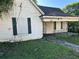 Exterior shot of a house with peeling white paint, boarded windows and a overgrown lawn at 1103 Windsor St, Atlanta, GA 30310