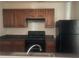 Cozy kitchen featuring wood cabinets, black appliances, and stainless steel sink at 14104 Fairington Circle Ridge, Stonecrest, GA 30038