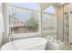Elegant bathroom with a modern tub, walk-in shower, and window overlooking the backyard at 3405 Glenrose Trail Trl, Atlanta, GA 30341