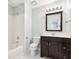 Bright bathroom features a tub with white tile surround, dark wood vanity, and a decorative mirror at 3405 Glenrose Trail Trl, Atlanta, GA 30341