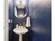 Stylish powder room with dark blue walls, a round mirror, and a pedestal sink at 3405 Glenrose Trail Trl, Atlanta, GA 30341