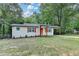 Charming renovated home with an orange front door, cedar shutters, and a covered carport at 737 Bolton Nw Rd, Atlanta, GA 30331