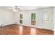 Airy living room featuring wood floors, a ceiling fan, and a front entry door at 240 Wellington Dr, Mcdonough, GA 30252