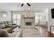 Cozy living room featuring cherrywood floors, a stone fireplace, and lots of natural lighting at 3210 Lake Pointe Cir, Roswell, GA 30075