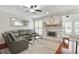 Spacious living room featuring cherrywood floors, a stone fireplace, and windows with plantation shutters at 3210 Lake Pointe Cir, Roswell, GA 30075