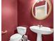 Cozy half bathroom features a pedestal sink, round mirror and a modern low-flow toilet at 1254 Williston Dr, Lawrenceville, GA 30044