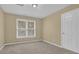 Bedroom with a large window, beige carpet, and a white door at 1254 Williston Dr, Lawrenceville, GA 30044