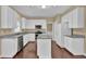 Bright kitchen featuring white cabinets, granite countertops, stainless steel appliances, and hardwood floors at 1254 Williston Dr, Lawrenceville, GA 30044
