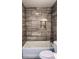 White tub is highlighted with gray tile and a shower with a built in niche at 2443 Abner Nw Pl, Atlanta, GA 30318