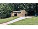 A charming home with a long driveway, lush green lawn, and mature trees providing a serene and private setting at 2443 Abner Nw Pl, Atlanta, GA 30318