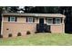 Close-up of a freshly painted brick home with black shutters and a modern black railing by the front door at 2443 Abner Nw Pl, Atlanta, GA 30318