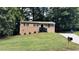 Charming ranch-style home featuring a brick facade, complemented by a well-manicured lawn and mature trees at 2443 Abner Nw Pl, Atlanta, GA 30318