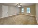 Bright bedroom with neutral walls, carpet, ceiling fan, and two large windows at 247 Millbrook Farm Rd, Marietta, GA 30068