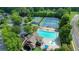 Beautiful aerial shot of the community pool, clubhouse, tennis courts, playground, and parking area surrounded by trees at 1630 Eaglerock Dr, Suwanee, GA 30024