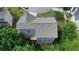 An aerial view of a gray home with a gray shingled roof, situated among lush trees in a suburban neighborhood at 1630 Eaglerock Dr, Suwanee, GA 30024