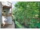 View of a wooden deck with patio furniture, next to a black metal fence overlooking trees on a sloped yard at 1630 Eaglerock Dr, Suwanee, GA 30024