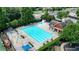 Aerial view of a community pool with lounge chairs, a splash pad, and nearby buildings in a suburban setting at 1630 Eaglerock Dr, Suwanee, GA 30024