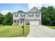 A stunning two-story house with brick accents, vinyl siding, shutters, and an attached garage at 1630 Eaglerock Dr, Suwanee, GA 30024