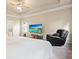 Bright bedroom with tray ceiling, ceiling fan, carpeting, large windows, and a TV on a wooden stand at 1630 Eaglerock Dr, Suwanee, GA 30024